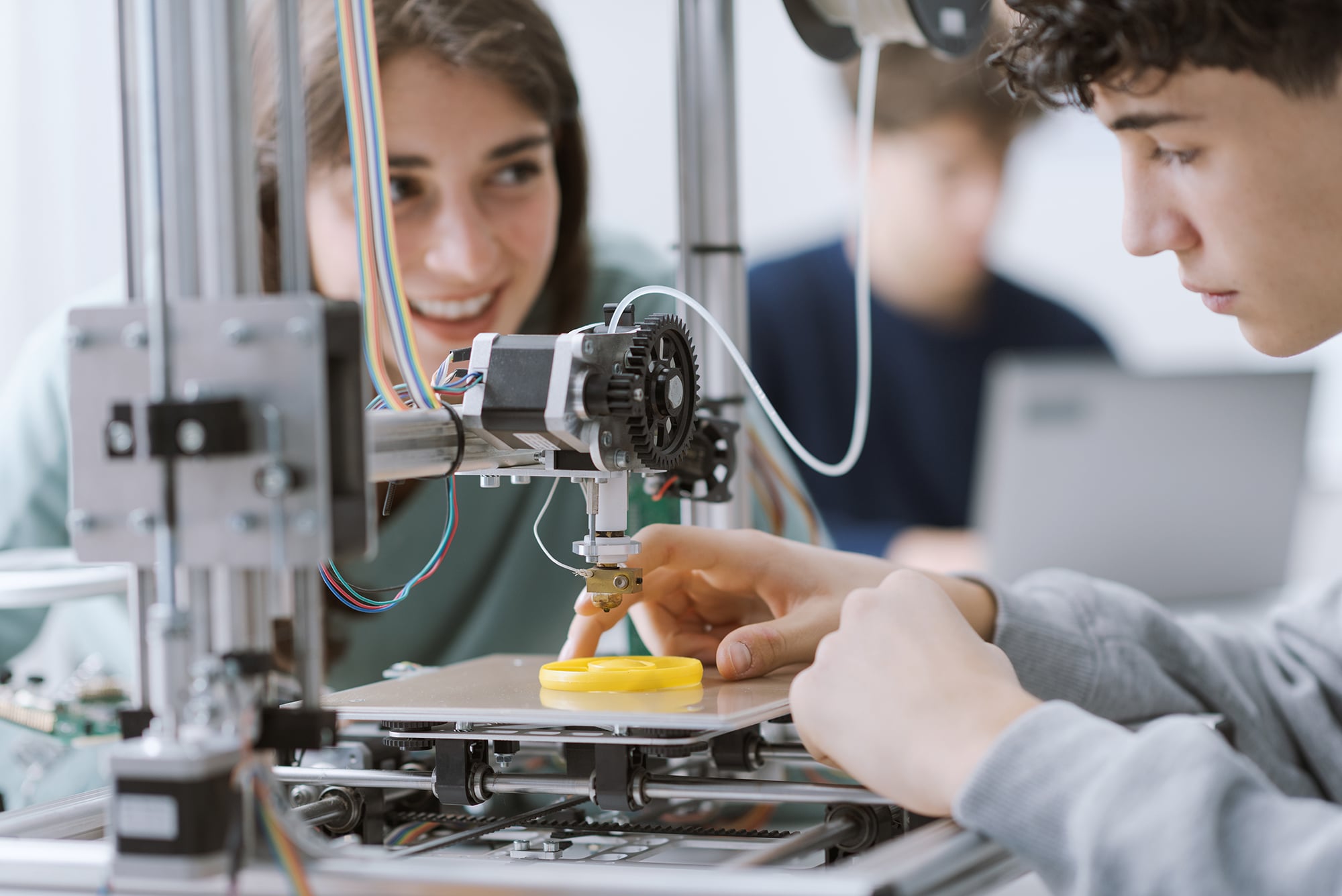 Students learning how to use a 3D printer in the lab Students using 3D printer.